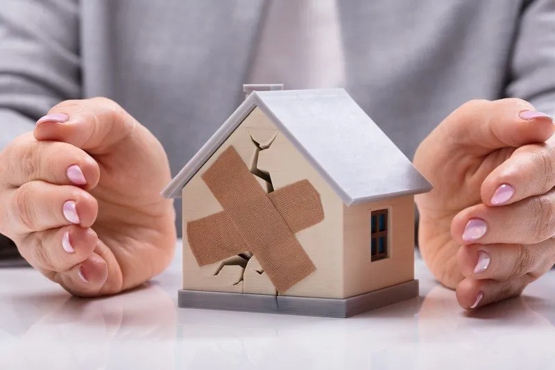 Toy house with crack and band aid image