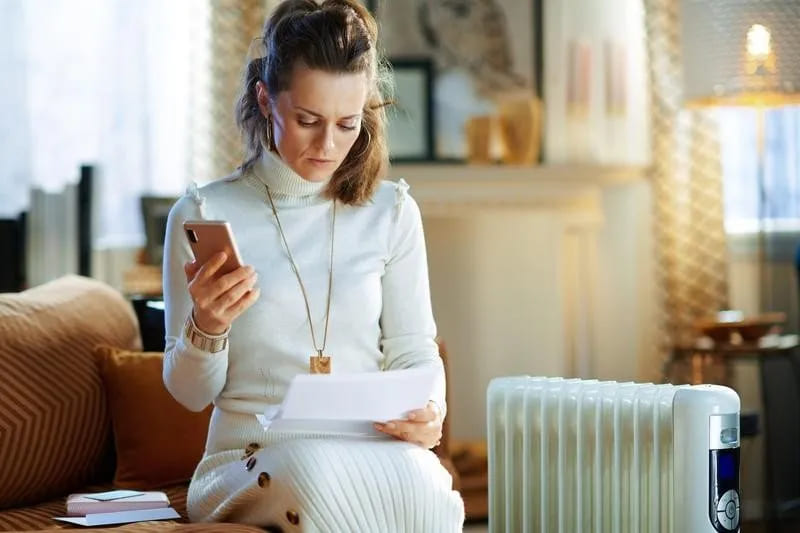 Female looking at paper with phone in hand image