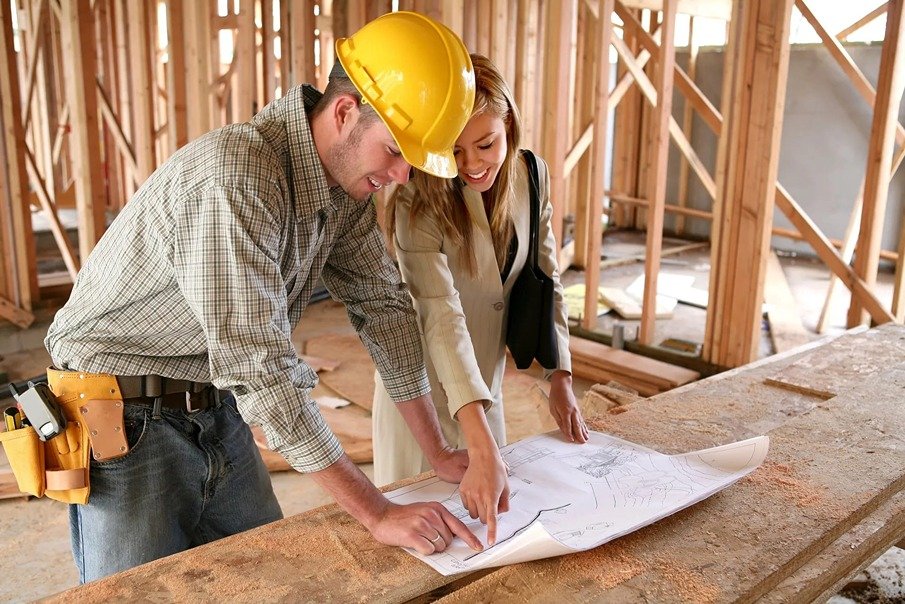 Contractor and designer reviewing details on a job site at framing stage