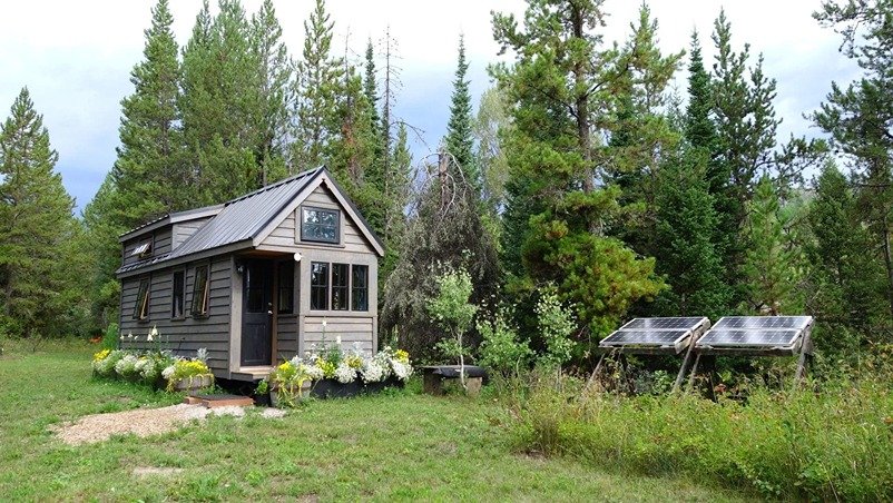 Tiny house in the woods with solar panels